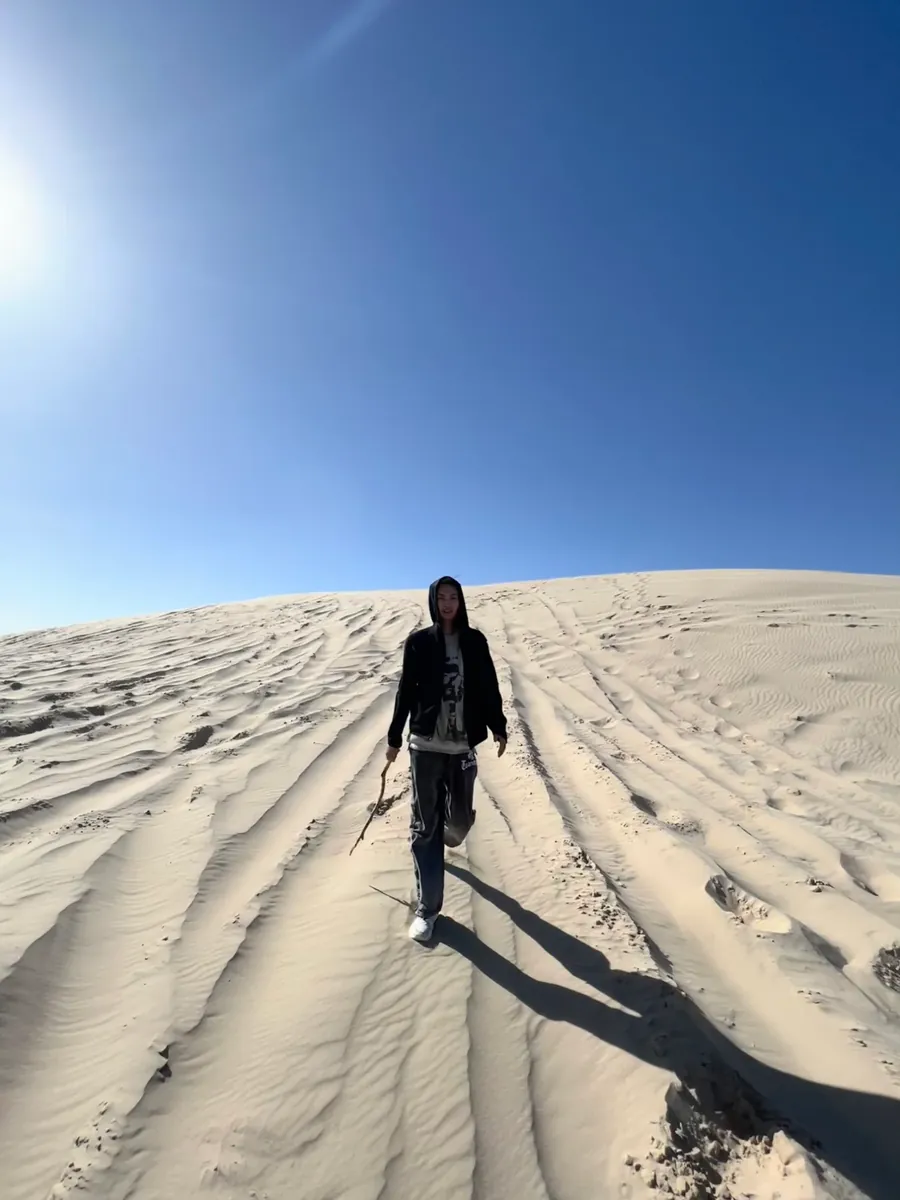 Walking up a sand dune under a blue sky