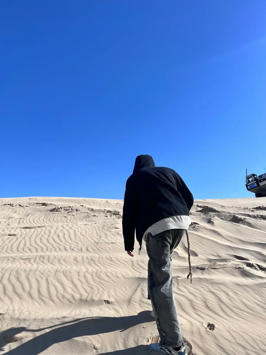 Climbing a sand dune, seen from behind