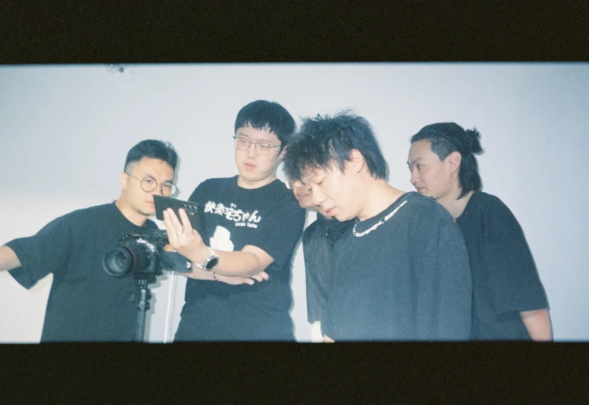 Film crew huddled around a camera in a studio